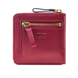 11 of 39:A TUSK New York pebbled leather zip-around wallet in a deep magenta pink, featuring gold-tone hardware, a front zip pocket with a leather pull tab, and a wristlet strap on a white background.