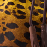 4 of 5:Close-up of a leopard print fabric with tassels on a yellow background