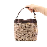 16 of 29:Handbag with leopard print pattern held by a hand on a white background