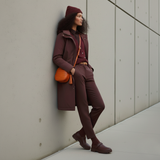 11 of 16:Woman in a brown outfit leaning against a wall