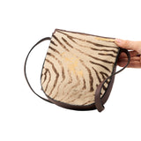 5 of 15:Handbag with zebra print pattern held by a hand on a white background
