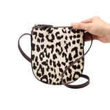 12 of 15:Leopard print crossbody bag held by a hand on a white background