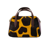 1 of 64:Handbag with black and yellow abstract pattern on a white background