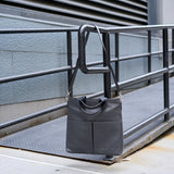 14 of 20:Gray handbag hanging on a metal railing outdoors