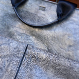 12 of 16:Close-up of a textured blue bag with a visible brand logo.