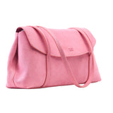 11 of 20:Three-quarter profile view of the blush pink Italian suede Vienatta | Jyoti shoulder bag, showcasing its softly structured side silhouette, stitched flap closure with the Tusk logo stamped on the front, and thin double shoulder straps against a plain light gray background - BLUSH