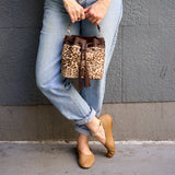2 of 29:Person wearing leopard print handbag and beige shoes against a gray wall - BLACK/TAN